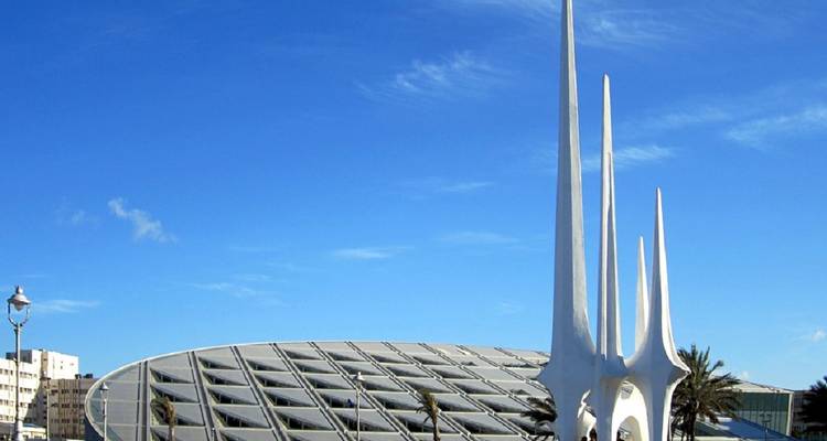 Une structure architecturale moderne avec des flèches se détachant sur un ciel bleu clair.