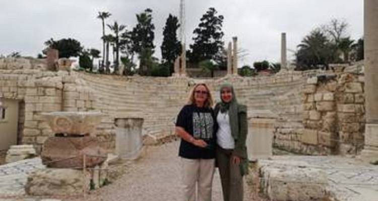 Deux personnes debout dans un amphithéâtre historique par temps nuageux.