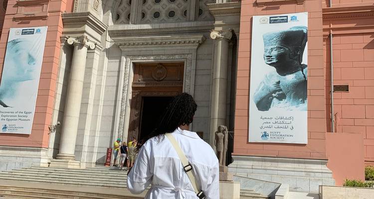 Back view of a traveller walking toward the ornate doorway of the Egyptian Museum.