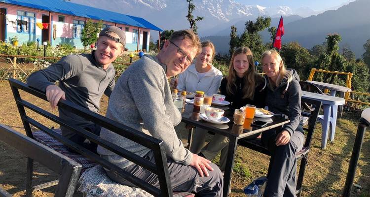 Famille profitant d'un repas avec les montagnes de l'Himalaya en arrière-plan.