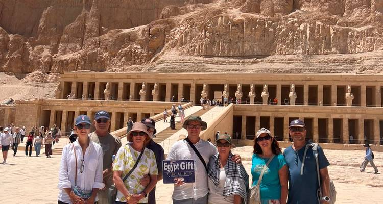 Grupo de turistas posa frente a las terrazas con columnas del Templo de Hatshepsut en Luxor.