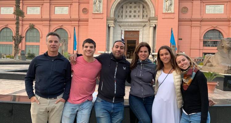 Groupe de voyageurs posant devant la façade rose du Musée égyptien.