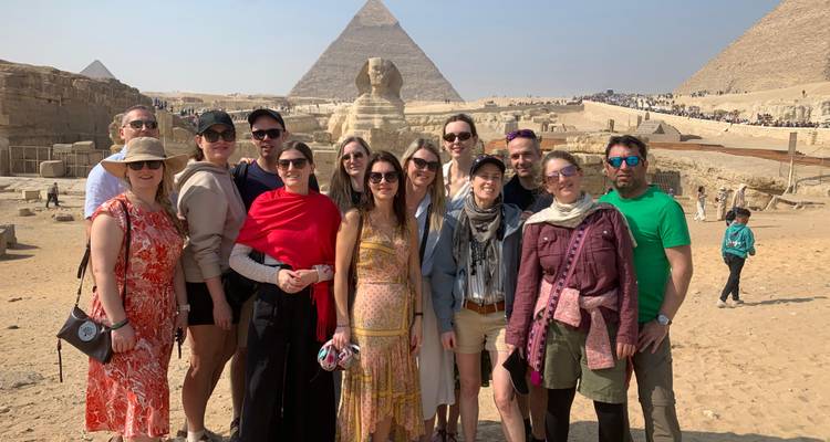 Les participants de la visite se rassemblent pour une photo avec le Sphinx et une pyramide en arrière-plan ensoleillé à Gizeh.