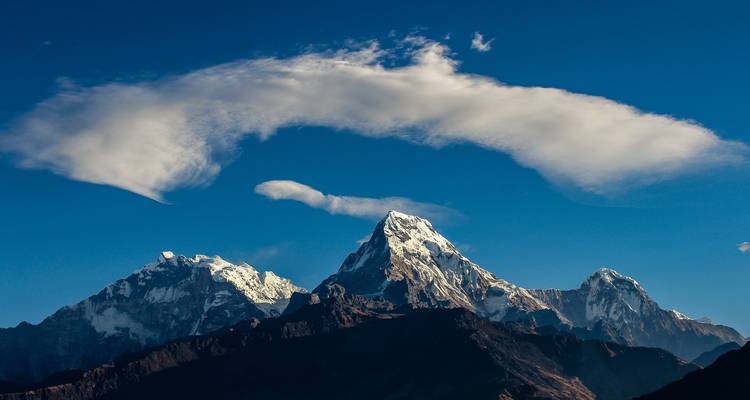 Snow-capped mountains with a unique cloud formation.
