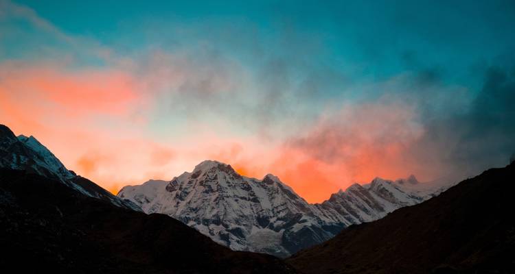 Colorful sunset behind snow-covered mountains.