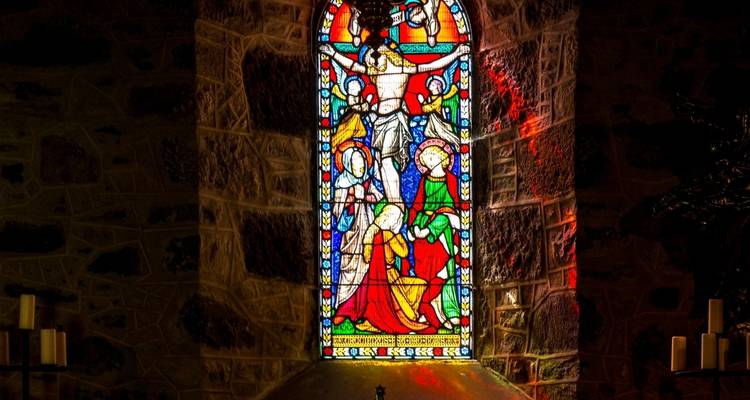 Vitrail coloré représentant une scène biblique à l'intérieur d'une église en pierre