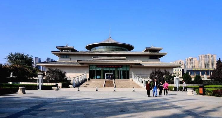 Menschen vor einem modernen Gebäude mit einem traditionellen Dach.