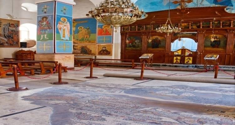 Interior of an ornate church with mosaics and icons.