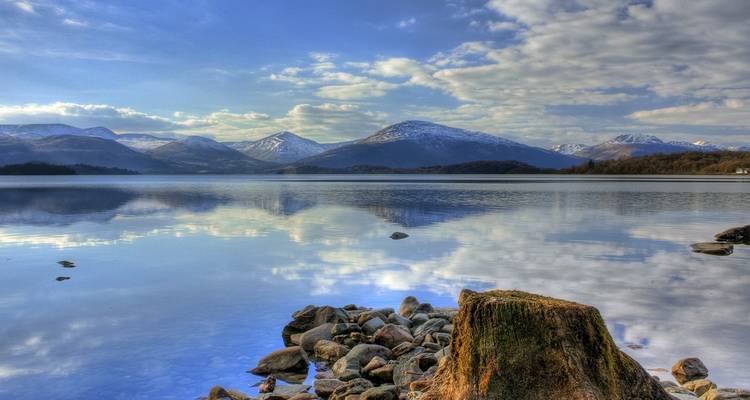 Beautiful lake with mountains in the background under a partly cloudy sky.