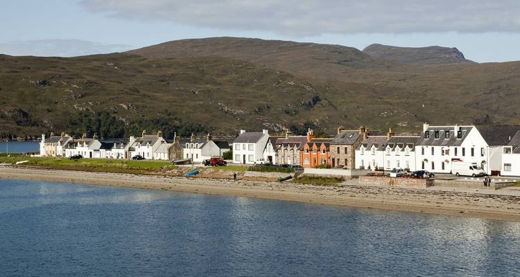 Coastal village with traditional houses under a clear sky.