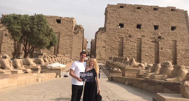 Stel dat poseert met een bord voor oude ruïnes.