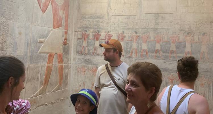 Menschen, die ägyptische Wandreliefs betrachten.