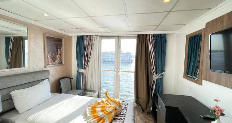 Habitación de hotel con cama y vista por la ventana de un río.