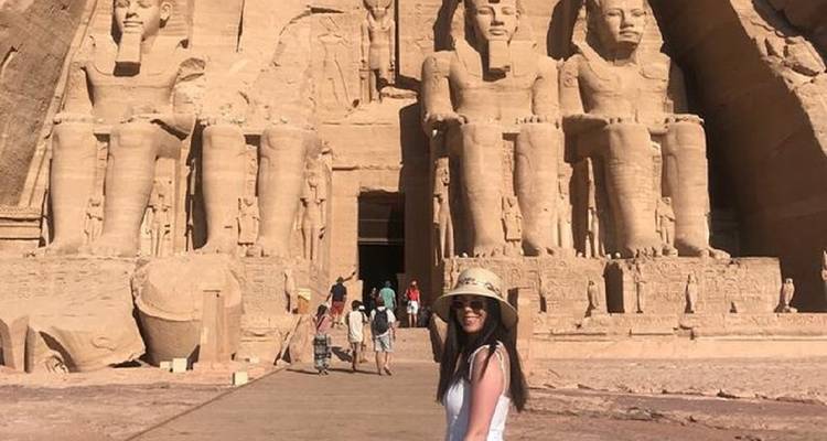 Vrouw in zomerhoed staande op de dijk met de Abu Simbel-tempel achter haar.