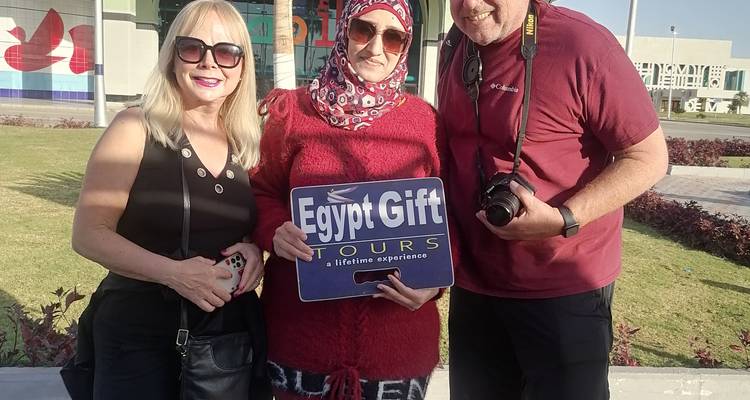 Trois personnes posant avec un panneau « Egypt Gift Tours ».