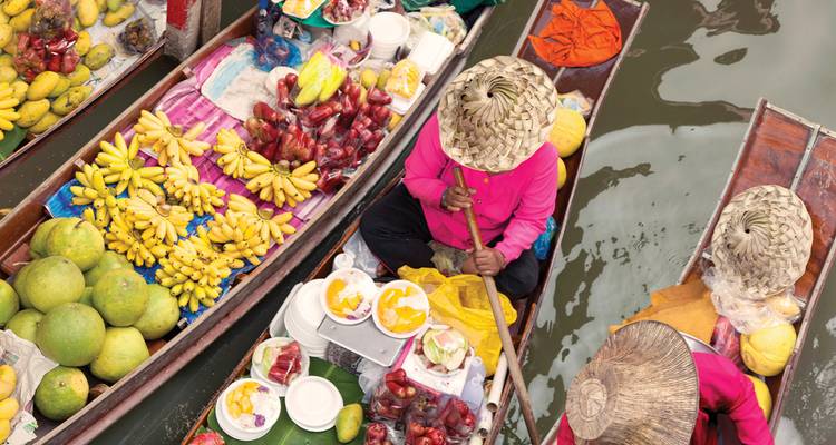 Draufsicht auf hell beladene Boote, die Obst auf einem Kanalmarkt schwimmend verkaufen.