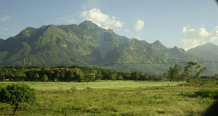 Mountain range with lush green foothills.