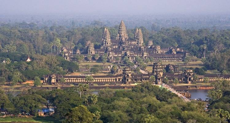 Una vista aérea espectacular del complejo de piedra masivo de Angkor Wat emergiendo de la densa selva verde.