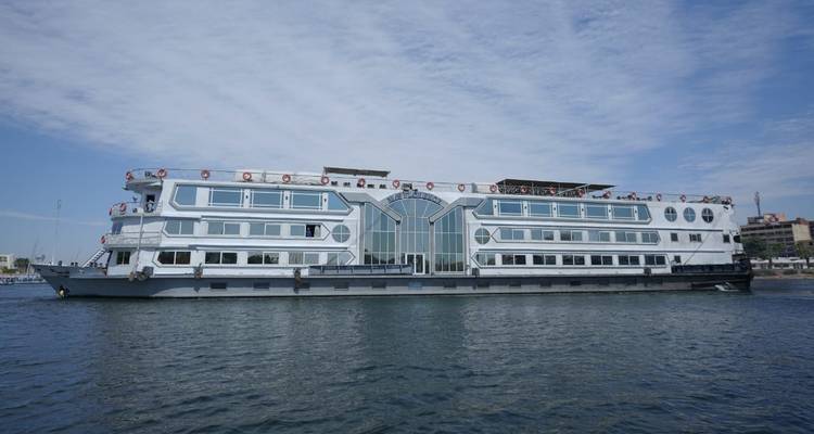 Grand navire de croisière sur une rivière avec un ciel bleu dégagé.