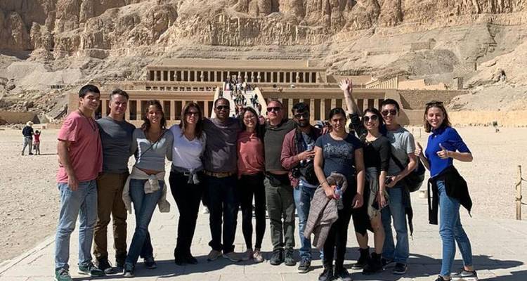 Group of people posing in front of a large ancient temple structure.