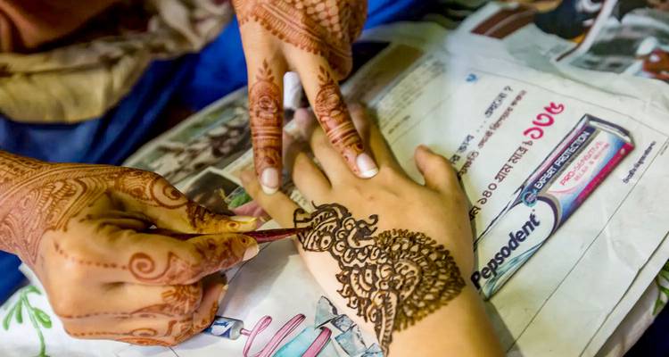 Henna being applied to hand.