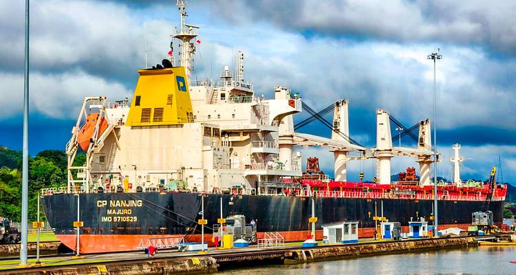 Grand cargo dans le canal de Panama sous un ciel nuageux.