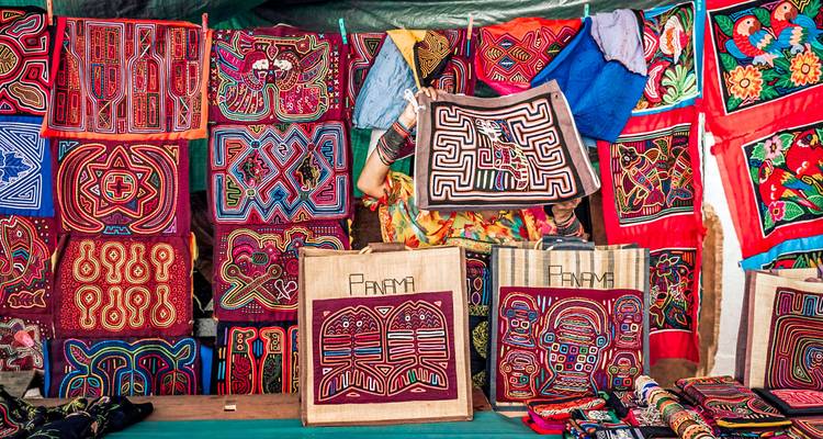 Telas coloridas y artesanías exhibidas en un mercado.