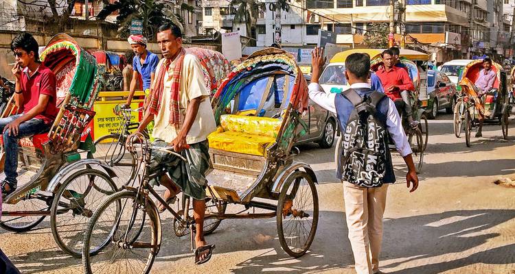 Straße voller Rikschas und Menschen.
