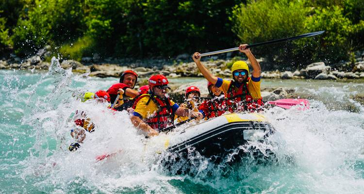 Groupe excité faisant du rafting dans des eaux turbulentes.