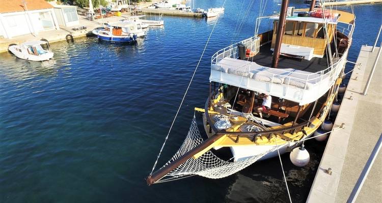 Boat docked at a harbor with clear water.