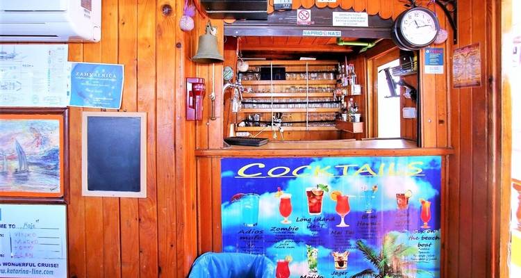 Wooden bar counter with a cocktail menu on a boat.