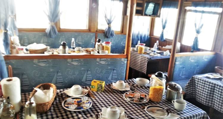 Interior dining area on a boat set for breakfast.