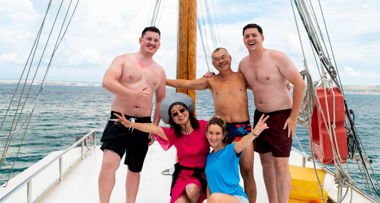 A group of people on a boat posing for a photo.