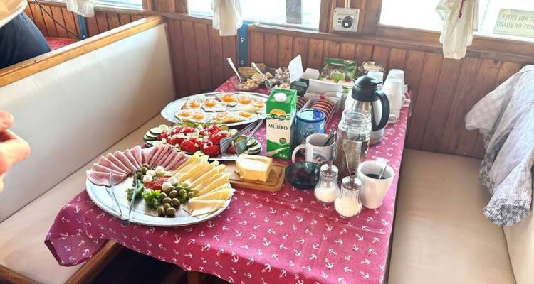 Table de petit-déjeuner avec des assiettes de jambon, fromage et œufs.