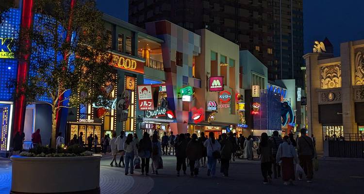 Crowd walking through a neon-lit street in Tokyo, Japan at night.