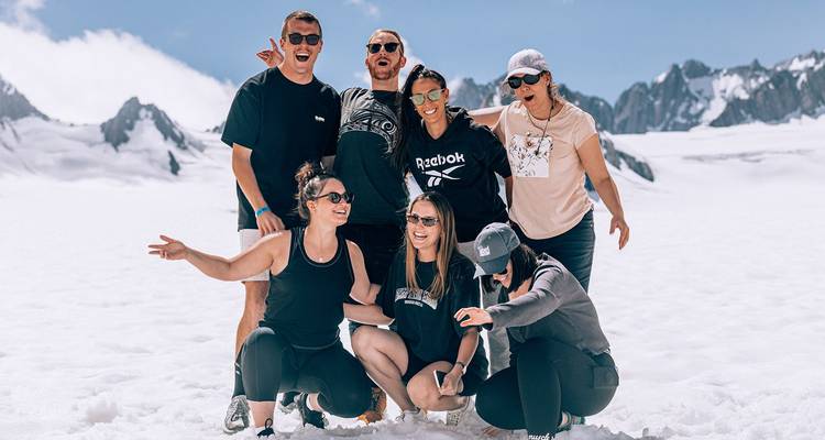 Groupe de personnes dans les montagnes enneigées, posant joyeusement.