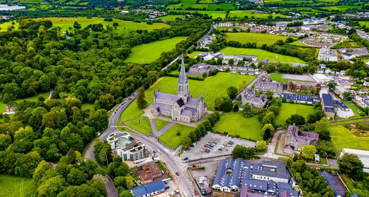 Luchtfoto van een historische kerk met omliggend groen landschap.