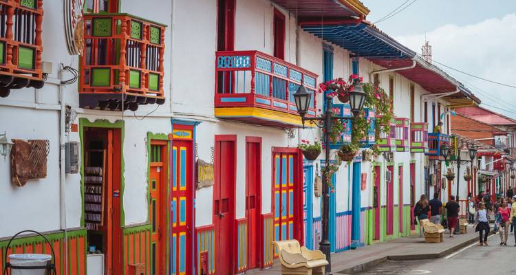 Vibrante hilera de balcones y puertas de madera pintada bordea la calle principal de un colorido pueblo colombiano