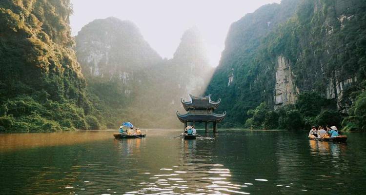 Toeristen in boten die de schilderachtige waterweg verkennen omringd door dramatische karstformaties.