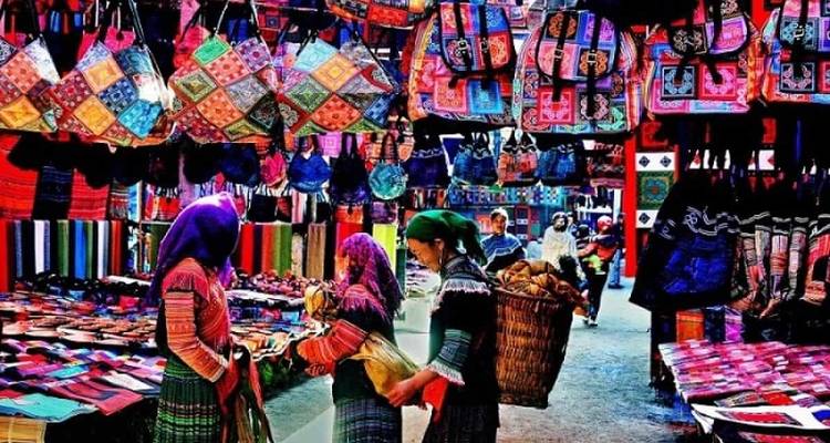 Lokale markt met kleurrijke textiel en mensen.