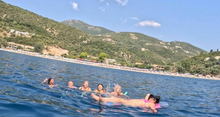 Groupe de personnes nageant et flottant dans une baie.