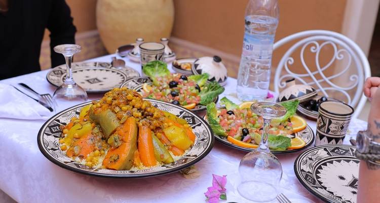 Repas traditionnel marocain avec couscous et légumes.