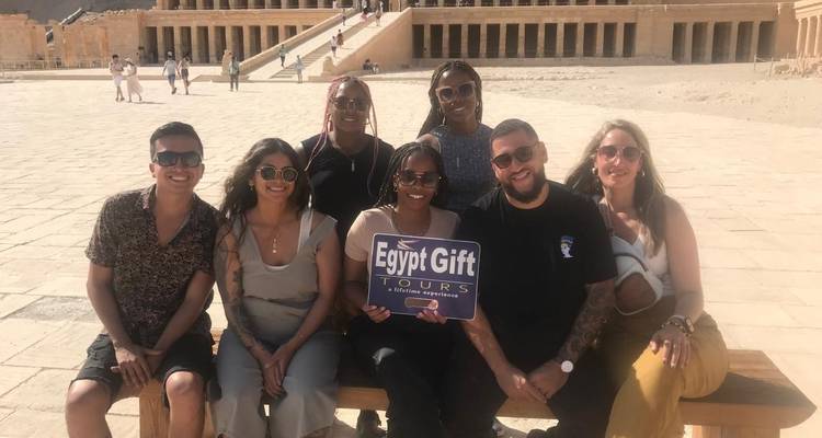 Group photo in front of a temple with a sign.