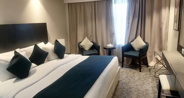 Chambre d'hôtel avec un grand lit et un coin salon.