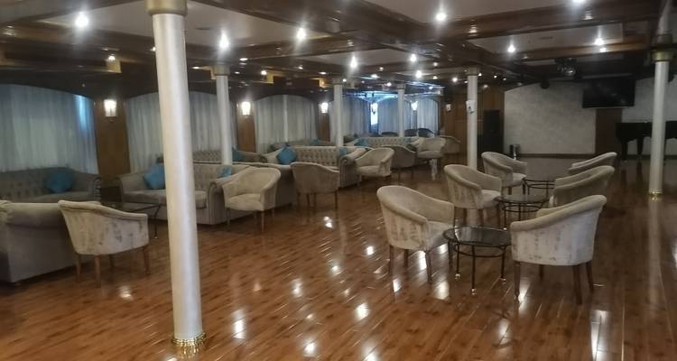 Salon d'hôtel spacieux avec plusieurs espaces de détente.