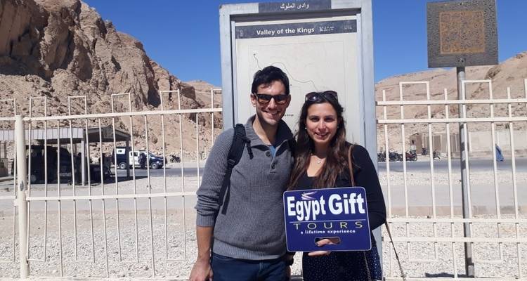 Pareja sosteniendo un cartel en el Valle de los Reyes.