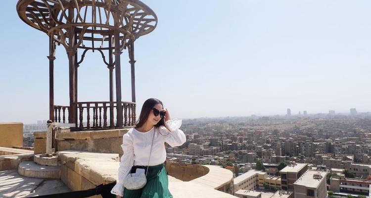 Mujer de pie en una azotea con el horizonte de El Cairo.