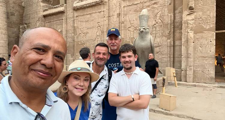 Groepselfie van een klein groepje in de versierde stenen binnenplaats van de Edfu-tempel met een valkebeeld