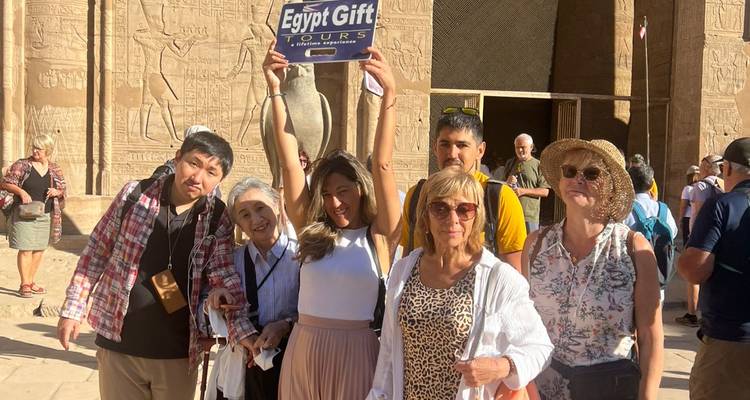 Gasten tillen Egypt Gift-bord op terwijl ze voor de ingang van de Edfu-tempel voor oude sculpturen staan