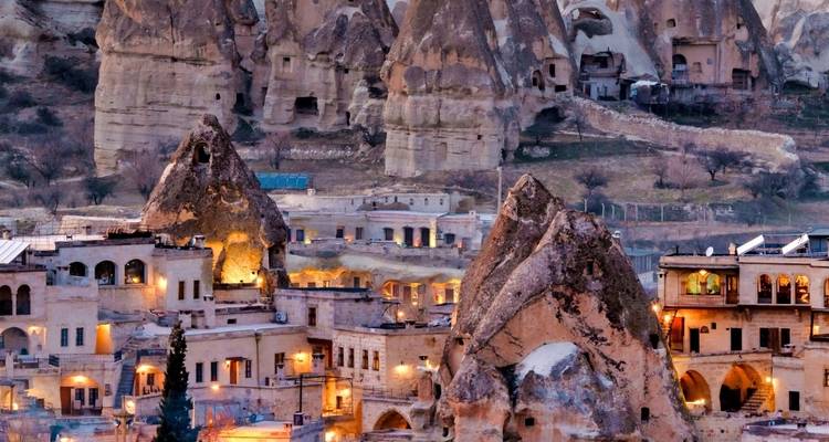 Fairy chimneys and dwellings carved into rocks at twilight.